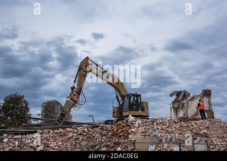 Demolitore che distrugge la vecchia stazione ferroviaria di Rodzkie, piccolo villaggio della provincia polacca di Lodzkie Foto Stock