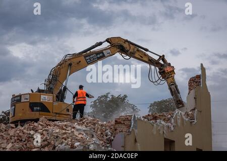 Demolitore che distrugge la vecchia stazione ferroviaria di Rodzkie, piccolo villaggio della provincia polacca di Lodzkie Foto Stock