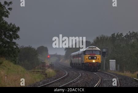 Locomotiva classe 47 47593 trasporto delle carrozze 'Staycation Express' Un insediamento piovoso molto umido e Carlisle Railway a Horton A Ribblesdale Foto Stock