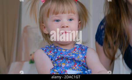 Bambina gioca su legno bianco cavallo a dondolo. Famiglia, dell'infanzia, gioco e concetto di piacere Foto Stock