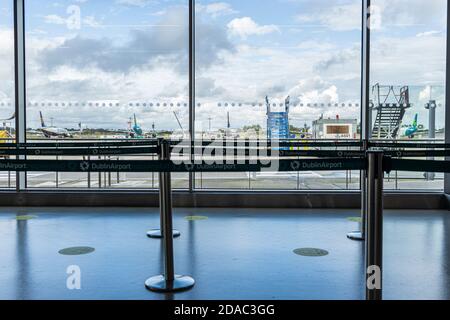 Vista attraverso le finestre di un cancello di partenza nel Terminal 1, con gli aerei Ryanair e Aer Lingus parcheggiati, e gradini di imbarco mobile, aeroporto di Dublino, D. Foto Stock