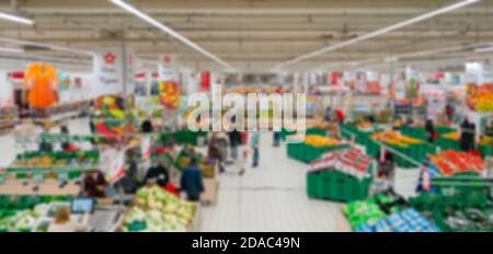 Supermercato sfocato. Vendita di prodotti in un negozio al dettaglio. Sfondo sfocato degli acquirenti in un negozio. Foto Stock