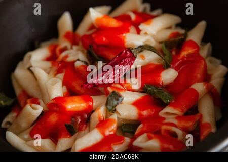 Maccheroni bianchi con pomodoro, peperoncino, origano, formaggio e spezie Foto Stock