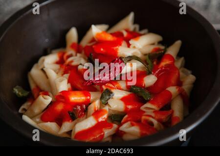 Maccheroni bianchi con pomodoro, peperoncino, origano, formaggio e spezie Foto Stock