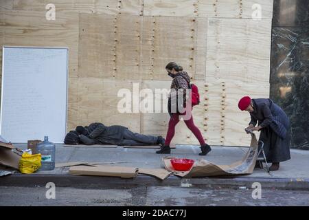 L'uomo senza dimora sonnsonnson il marciapiede nel centro di Manhattan, New York City. Foto Stock