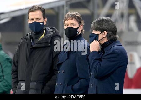 11 novembre 2020, Sassonia, Lipsia: Calcio: Partite internazionali, Germania - Repubblica Ceca nella Red Bull Arena. Oliver Bierhoff (l-r), direttore delle squadre nazionali e accademia, assistente allenatore Marcus Sorg e Joachim Löw, allenatore della Germania, sono in piedi al bordo del campo con protezione bocca e naso prima dell'inizio della partita. NOTA IMPORTANTE: In conformità con le norme del DFL Deutsche Fußball Liga e del DFB Deutscher Fußball-Bund, è vietato utilizzare o utilizzare nello stadio e/o scattare fotografie della partita sotto forma di sequenze di immagini e/o video Foto Stock