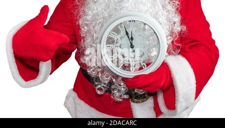 Babbo Natale tenendo un orologio bianco che mostra cinque minuti a mezzanotte e lui sta indicando esso. Concetto di Capodanno. Isolato su sfondo bianco. Foto Stock