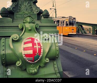 Liberty Bridge Coat of Arms dettaglio e tram sullo sfondo, Budapest, Ungheria Foto Stock