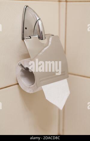 Porta carta igienica in acciaio inox con nuovo rotolo di carta, vista ravvicinata Foto Stock