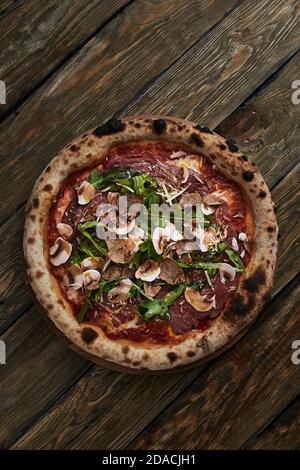 Primo piano su deliziosa pizza appena sfornata con fuso funghi di formaggio e rucola Foto Stock