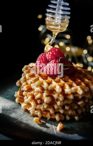 Viennese, Belga Golden soft cialde con miele su un bel piatto. Spazio di copia. Tasto basso Foto Stock