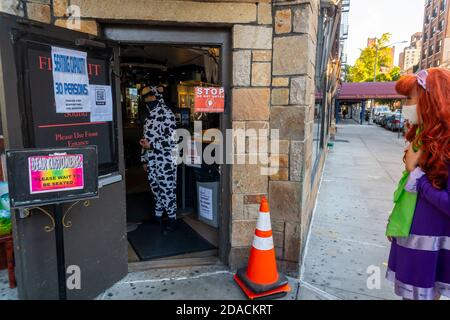 I portiere al bar Monster di Greenwich Village a New York sabato 31 ottobre 2020 indossano i loro costumi. Nonostante la parata annuale sia stata cancellata e virtuale, le persone sono uscite a mostrare il loro lato creativo.(© Richard B. Levine) Foto Stock