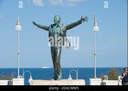 La statua in bronzo del popolare cantante italiano Domenico Modugno nella sua città di Polignano a mare, Bari, Italia. La statua fu gettata a Bari dalla fonderia Foto Stock