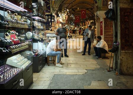 I lavoratori del negozio indossano maschere che si trovano all'esterno dei negozi di souvenir di gioielli nel Grand Bazaar, Istanbul, Turchia Foto Stock