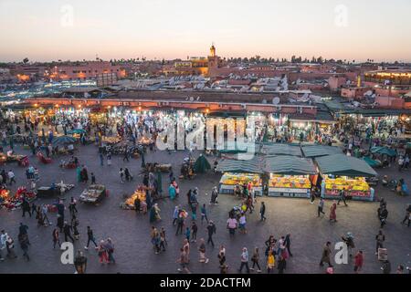 Marrakech, Marocco - APRILE 26 2019: Venditori e turisti visti da una terrazza nei bellissimi colori al tramonto nel centro di Medina Foto Stock