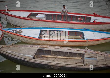 Varanasi, India, novembre 2015. Un uomo seduto in una barca sul fiume Gange. Foto Stock