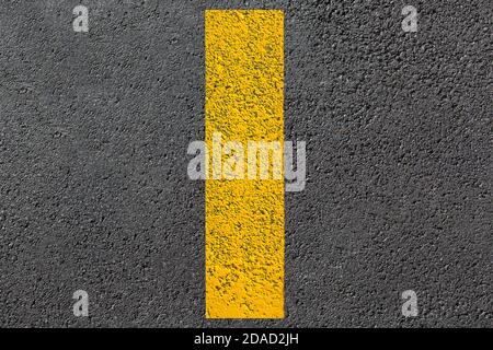 linea tratteggiata gialla di segnaletica stradale primo piano sulla nuova superficie stradale bituminosa asfaltata vista dall'alto della strada asfaltata granulosa, nessuno. Foto Stock