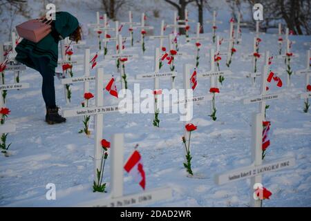 Calgary, Alberta, Canada. 11 Nov 2020. I membri del pubblico ispezionano croci commemorative il giorno della memoria, 11 novembre, presso il campo di croci memoriale a Calgary, Alberta. Il campo delle croci è un memoriale annuale che riconosce i quasi 120,000 veterani canadesi che hanno perso la vita in guerre dal 1914. Credit: Gavin John/ZUMA Wire/Alamy Live News Foto Stock