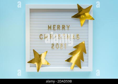 Cartellone con auguri natalizi 2021, decorazioni su sfondo blu pastello di girly. Composizione di Natale. Posa piatta, dall'alto Foto Stock