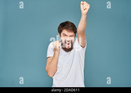 uomo in t-shirt bianca gesturing con le mani studio tagliato Foto Stock