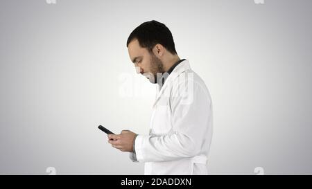 Medico ambulante o infermiera che testano su un telefono delle cellule sopra pendenza indietro Foto Stock