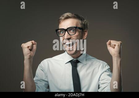 Felice uomo d'affari festeggiando con i pugni sollevati, il successo e il concetto di successo Foto Stock