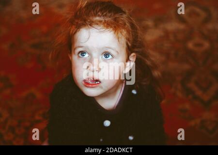 una ragazza gioca in un quartiere povero su un mucchio di ghiaia Foto Stock