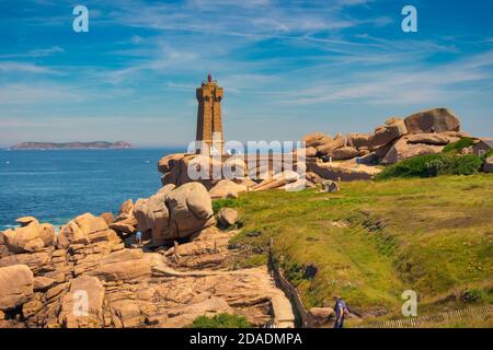 Faro Ploumanac'h immerso tra le rocce di granito rosa dove turisti sconosciuti camminano attraverso di loro. Bretagna, Francia Foto Stock