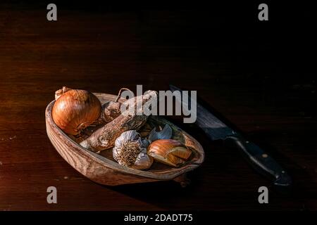 Piatto piccante. Cipolle, aglio e zenzero in una ciotola di legno. Foto Stock