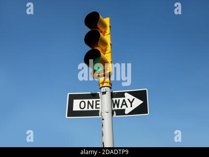 Incrocio a New York City. Semaforo e segnaletica stradale a senso unico contro il cielo blu Foto Stock