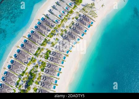 Atolli e isole nelle Maldive. Isola tropicale alle Maldive con ville d'acqua di lusso, bungalow su mare blu incredibile. Vacanza estiva, vista aerea Foto Stock