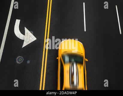 Segnaletica stradale su asfalto sulla strada di Manhattan a New York City. La cabina taxi con movimento blured si muove lungo la strada ad alta velocità. Punto iridescente o Foto Stock