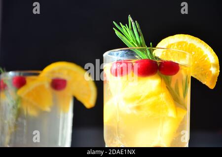 bicchiere di cocktail al bourbon al miele con bevanda a base di whisky al rosmarino con buccia d'arancia, con mirtilli rossi o punch con bevande calde invernali o vin brulé Foto Stock