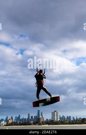 Un kite surfer è alzato nell'aria con il CBD di Melbourne sullo sfondo. Foto Stock