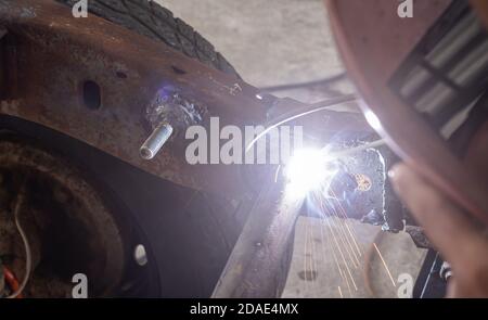 Saldatura del tubo metallico del telaio dell'auto mediante saldatura del lavoratore o. Uomo di saldatura nella vista Zoom Foto Stock