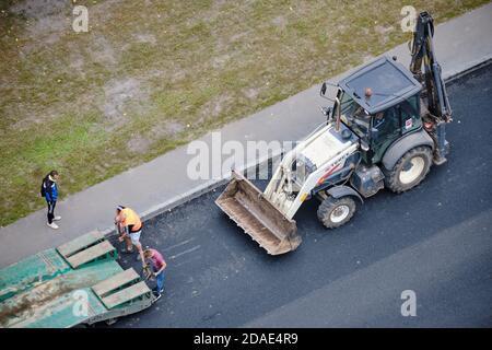 Caricamento dell'escavatore sulla piattaforma di un autocarro per il trasporto di attrezzature da costruzione - Mosca, Russia, 24 agosto 2020 Foto Stock