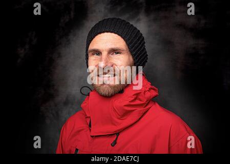 Bell'uomo in un cappello lavorato a maglia su sfondo scuro Foto Stock