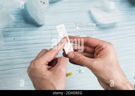 Un uomo che prende un test di anticorpi Covid-19 a casa. Foto Stock
