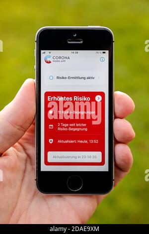 Germania - viene visualizzato il telefono cellulare con l'app di avviso corona aperta aumento del rischio con 11 incontri di rischio Foto Stock