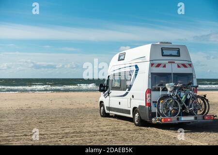 Camping Car RV in piedi sulla spiaggia di sabbia sul lungomare in giornata di sole. Romo Bilstrand, Lakolk Strand, Danimarca. Foto Stock