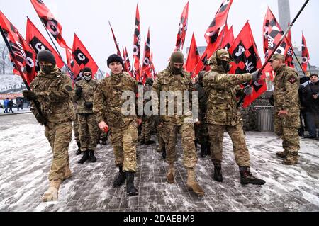 Colonna di lontani-destra ucraini che marciano sulla strada con bandiere In mani per celebrare il compleanno del grande leader nazionalista ucraino Stepanan bande Foto Stock
