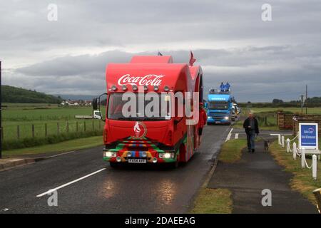 Ayrshire, Scozia, Regno Unito. La torcia olimpica di Londra 2012 viaggia attraverso l'Ayrshire del Sud, allietato dalle comunità locali e dai bambini della scuola. Il motociclo che porta la torcia e l'equipaggio di supporto arriva a Maidens, Ayrshire con scorta di polizia Foto Stock