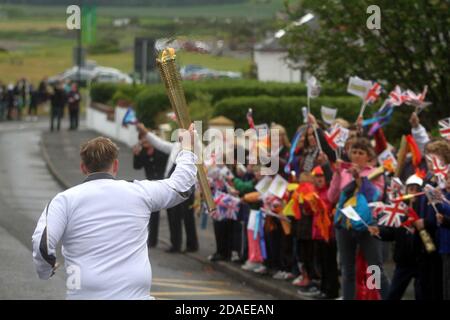 Maidens, Ayrshire, Scozia, Regno Unito. La torcia olimpica di Londra 2012 viaggia attraverso l'Ayrshire del Sud, allietato dalle comunità locali e dai bambini della scuola Foto Stock