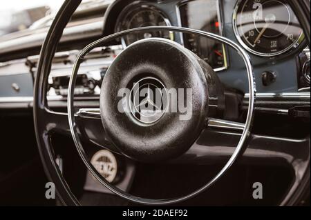 Primo piano sul volante di una classica Mercedes-Benz. Foto Stock