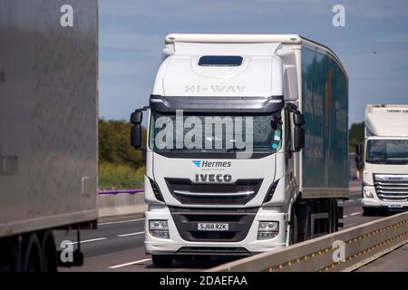 Autocarri che viaggiano lungo i lavori stradali sull'autostrada M1 nelle Midlands, Inghilterra. Foto Stock