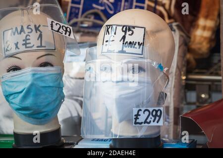 Londra, UK - 3 novembre 2020 - maschere facciali e scudi esposti su teste di manichino in vendita al mercato di Walthamstow Foto Stock