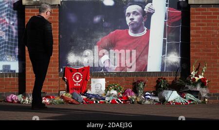 Tributi al di fuori di Old Trafford prima che il servizio e commit dell'ex giocatore Manchester United Nobby Stiles si svolgeranno più tardi. Foto Stock