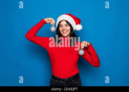 Giovane bella donna che indossa un cappello di natale su sfondo bianco molto felice ed eccitato facendo gesto vincitore con braccia sollevate, sorridente e screami Foto Stock