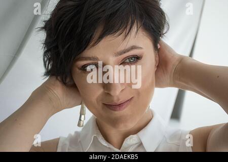 Primo piano tenero ritratto di un volto femminile, bruna dai capelli corti Foto Stock
