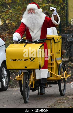 Himmelpfort, Germania. 12 Nov 2020. Babbo Natale arriva a Himmelpfort con una bicicletta elettrica dall'Ufficio postale tedesco. Fino alla vigilia di Natale risponderà di nuovo alle lettere dei bambini provenienti dalla Germania e da tutto il mondo con il sostegno dei suoi 20 assistenti impegnati. Tuttavia, a causa del pericolo continuo di infezione corona, non ci sarà purtroppo nessun ufficio postale di Natale accessibile pubblicamente quest'anno e Babbo Natale e i suoi angeli non possono essere visitati nel villaggio di Natale. Credit: dpa Picture Alliance/Alamy Live News Foto Stock